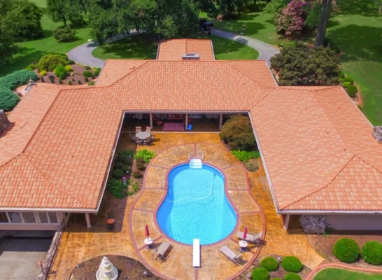 Aerial view of a spacious home with a pool shows the craftsmanship of a roofing tiles manufacturer