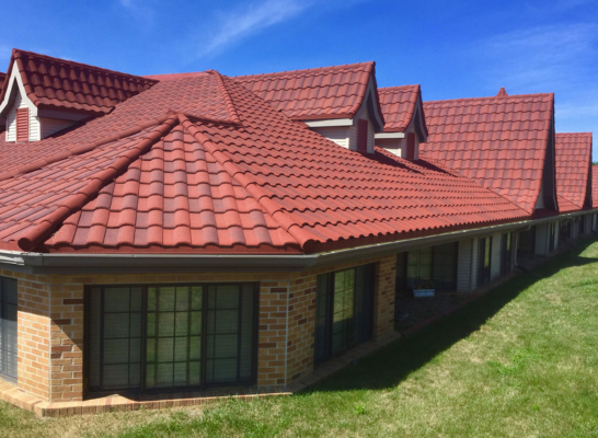 Red tile roof house with windows, showcasing quality roofing tiles from a reputable manufacturer