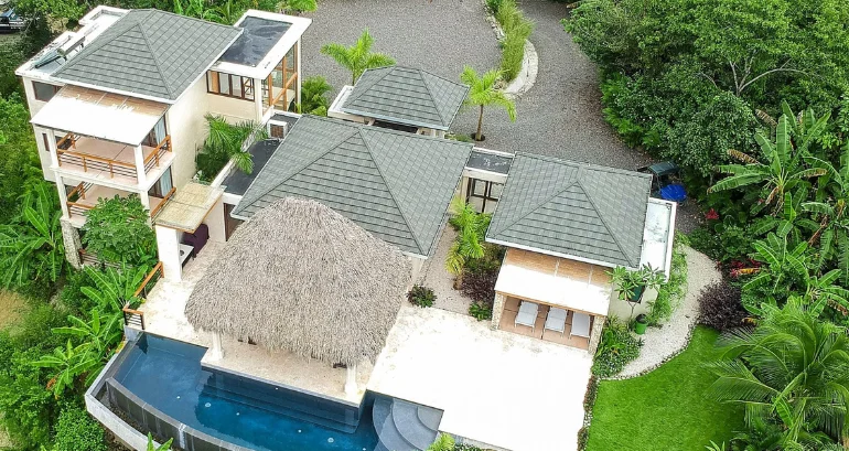 Aerial view of a tropical villa set in lush flora with artistic roofing tiles gives a lavish look.