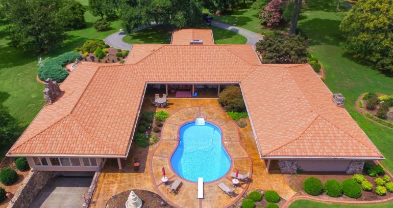 Aerial view of a large resort's roofing shingles and pool in nature, with a striking aspect.