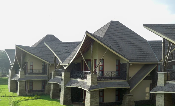 A modern homes with peaked roofs, stone and wood design, spacious balconies, and nice green lawns.